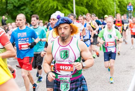 A photo of a man wearing a tartan hat running the Edinburgh Marathon