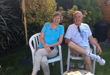 A photo of Lynda and her husband sitting in the garden in the sunshine