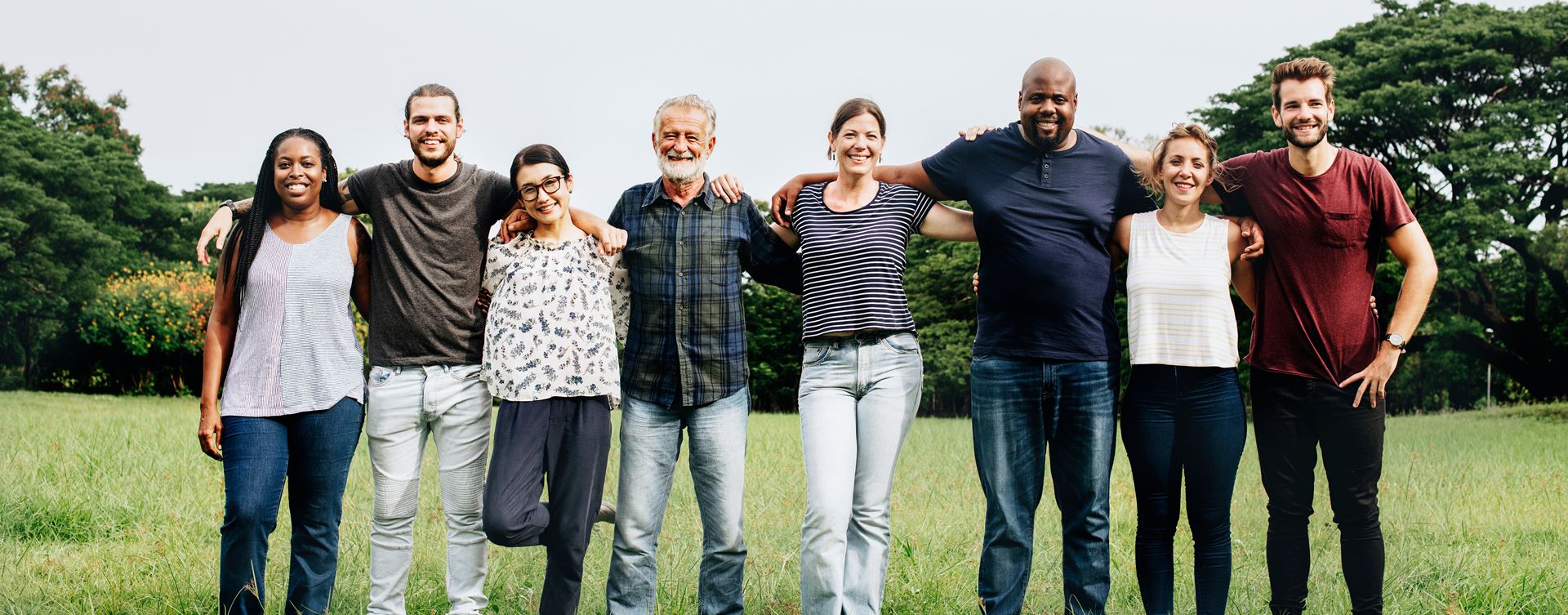 Diverse group of people smiling together in a field