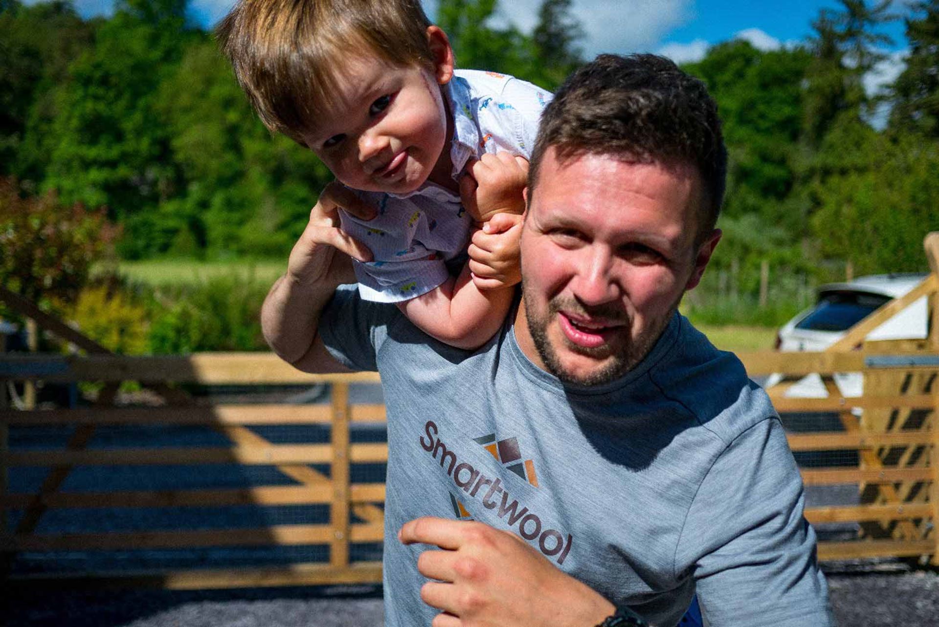 Worldwide Cancer Research supporter Jack outside holding his son George in the sunshine
