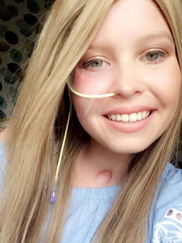 A selfie photograph of Eilidh wearing a wig during her treatment and smiling at the camera 