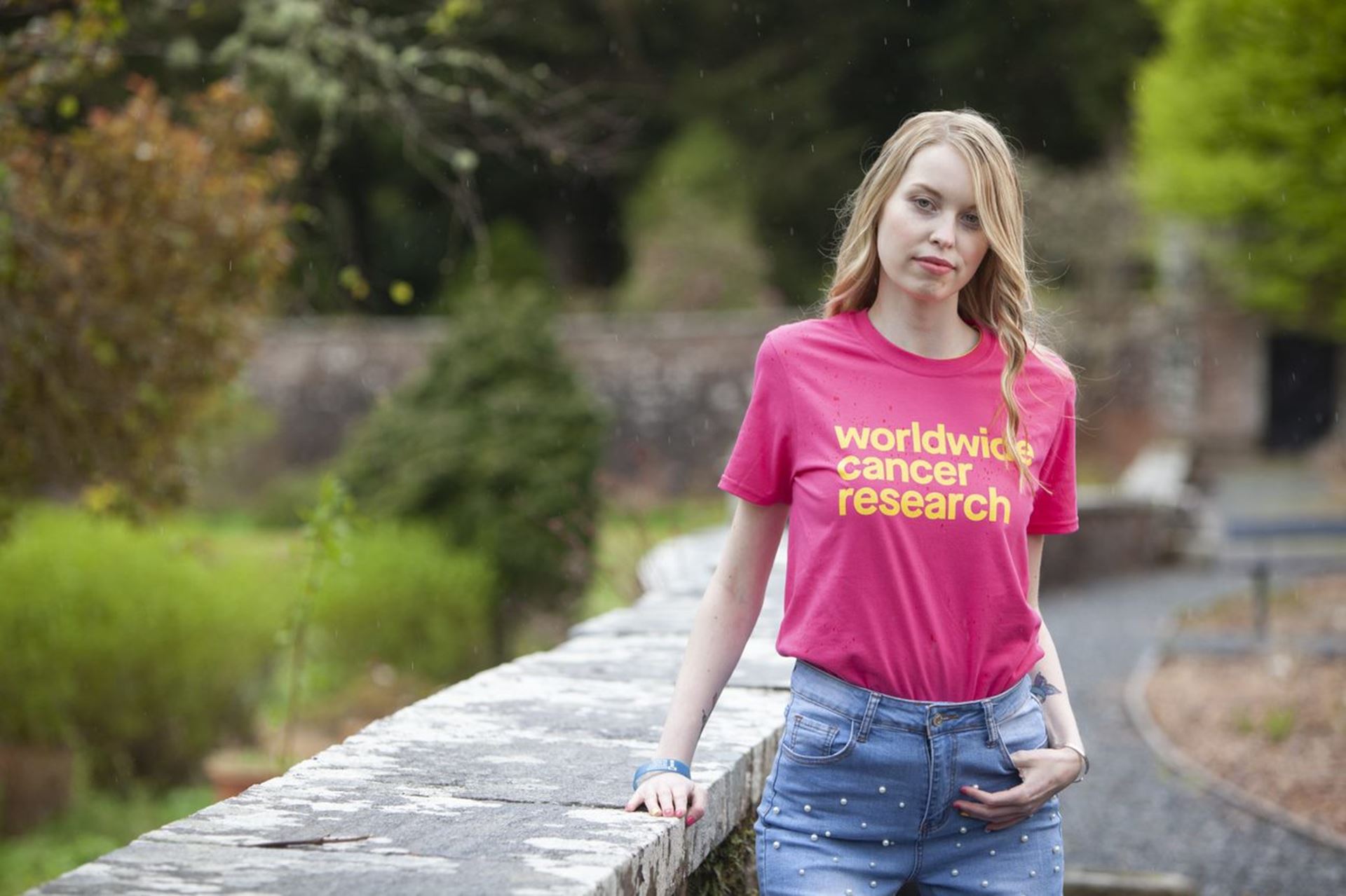 Eilidh standing outside wearing a Worldwide Cancer Research tshirt