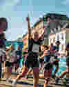 Runners in the Superhalf Copenhagen Half Marathon turn a corner with one runner throwing her hands up to the sky in celebration.