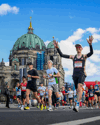 Runners in the Berlin Half Marathon run past the Berlin Cathedral.