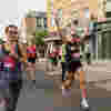 Runner with hands up running in the Hackney Half Marathon