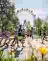 Runners in the Vienna Half Marathon run on a road with flowers in the foreground and a ferris wheel in the background.