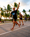 Runners in the Miami Marathon on a palm-tree lined street.