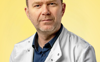 An image of Dr Niall Kenneth wearing a lab coat against a yellow background