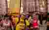 Man in a yellow t-shirt and flag running London Landmarks Half Marathon