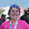 A smiling Sian looking directly at the camera wearing a hot pink running top and her medal for finishing the Brighton Marathon